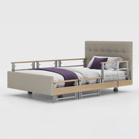 Opera Beds Signature Comfort Plus Profiling Bed with wooden accents, adjustable side rail and wheels, front view.