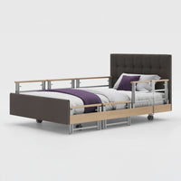 Signature Comfort Plus Profiling Bed with side rails, leatherette frame and white bedding, side view.