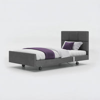 Opera Beds Signature Comfort Profiling Bed with adjustable frame, white bedding and four wheels, side view.