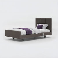 Profiling bed with frame, headboard, white bedding, purple blanket and rails, leatherette finish, front view.