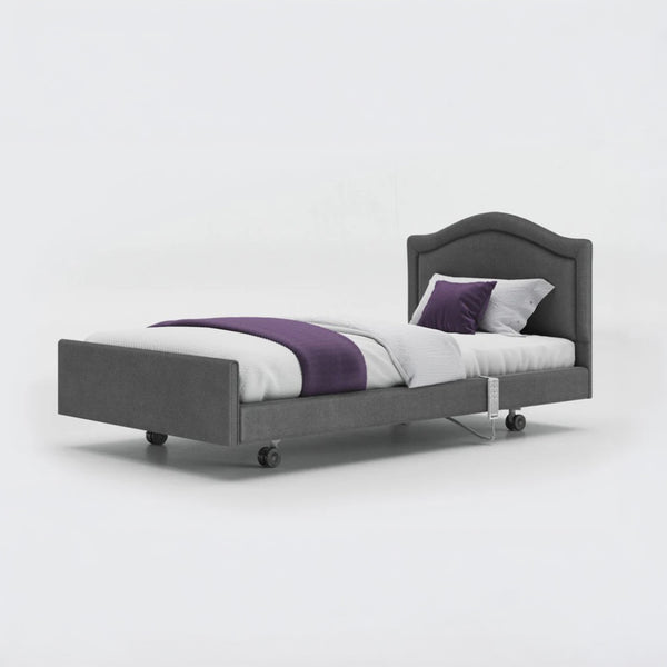 Opera Beds Signature Comfort Profiling Bed with wheels and bedding on a plain white background, side view.