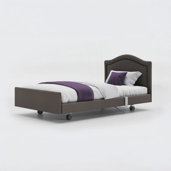 Profiling bed with white bedding, purple blanket and two pillows on a grey frame, leatherette finish, front view.