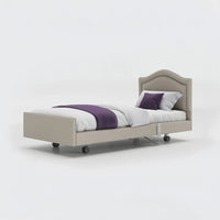 Opera Beds Signature Comfort Profiling Bed with white bedding and purple accents on a white background, front view.