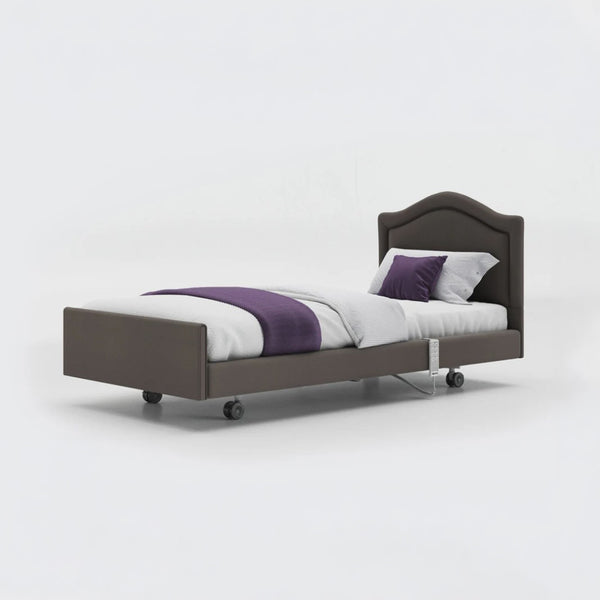 Profiling bed with wheels, leatherette finish, sturdy frame, white bedding and purple accents, side view.