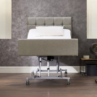 Opera Beds Signature Comfort Profiling Bed with raised head section, white pillow and modern decor, side view.