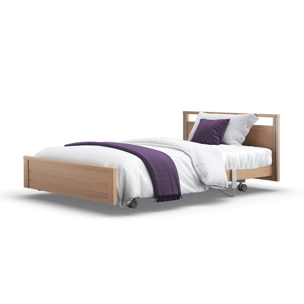 Signature Low Footboard Profiling Bed with wheels, white bedding, purple blanket and matching pillows, front angle.