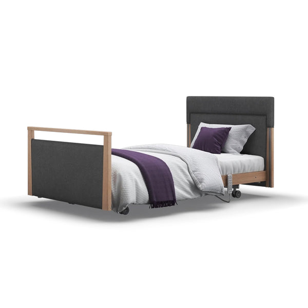 Opera Beds Signature Upholstered Profiling Bed with dark frame, white bedding and purple accent, side view.