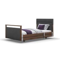 Opera Beds Signature Upholstered Profiling Bed with fabric frame, grey headboard, white and purple bedding, side view.