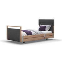 Opera Beds Signature Upholstered Profiling Bed with white bedding and purple accent pillows on a white background, front view.