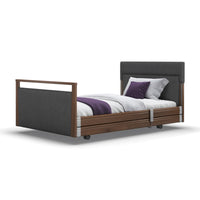 Opera Beds Signature Upholstered Profiling Bed with white bedding and purple pillows on a white background, front view.