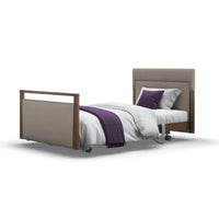 Signature Upholstered Profiling Bed with headboard, footboard, white bedding, purple blanket and wheels, front view.