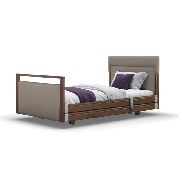 Opera Beds Signature Upholstered Profiling Bed with white bedding, purple blanket and pillow, on wheels, front view.