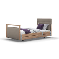 Opera Beds Signature Upholstered Profiling Bed with wooden frame, upholstered headboard, white bedding and purple accents, front view.