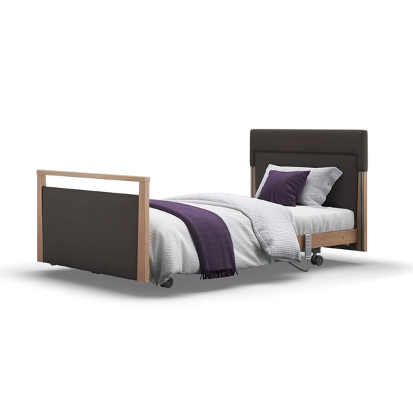 Signature upholstered profiling bed with leatherette, wood accents, black headboard, white bedding, purple throw and wheels, front view.