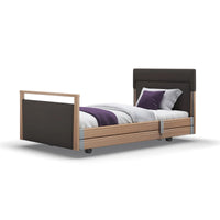 Opera Beds Signature Upholstered Profiling Bed with headboard and white sheets, angled view.