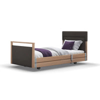 Opera Beds Signature Upholstered Profiling Bed with wood accents and purple pillows, angled view.