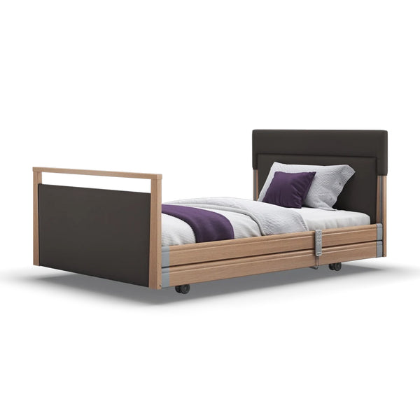 Opera Beds Signature Upholstered Profiling Bed with dark frame and headboard, white, grey, and purple bedding, front view.