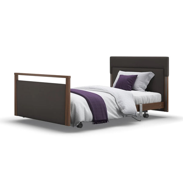 Upholstered profiling bed with dark frame, white bedding, purple accents, wheels and adjustable headrest, front view.