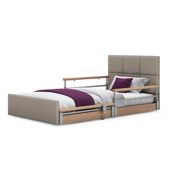 Solo Comfort Plus Profiling Floor Bed with linen fabric, wooden side rails and white bedding with a purple throw, front view.