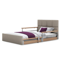 Opera Beds Solo Comfort Plus Profiling Floor Bed with wooden rails and bedding, linen fabric upholstery, angled side view.