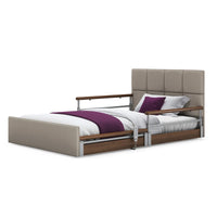 Opera Beds Solo Comfort Plus Linen profiling floor bed with side rails, white bedding, purple blanket and pillows, front view.