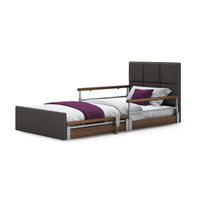 Opera Beds Solo Comfort Plus Profiling Floor Bed with side rails, white bedding, purple blanket and pillows, angled front view.