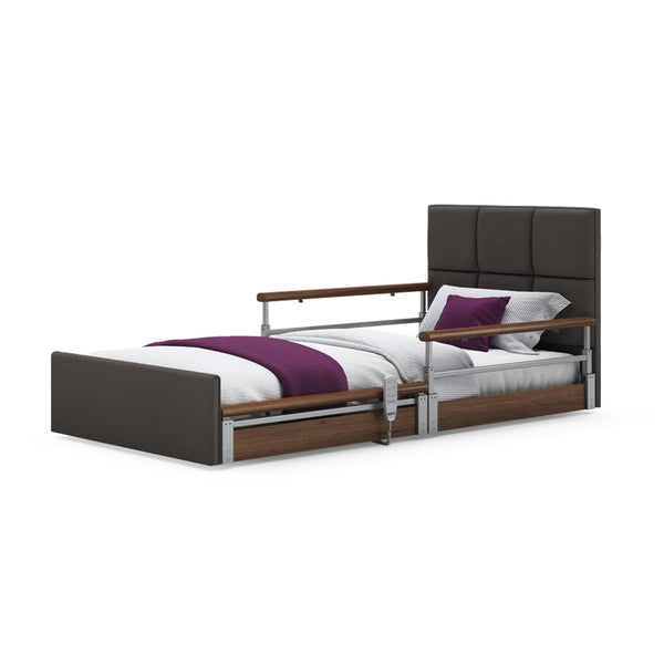 Opera Beds Solo Comfort Plus Profiling Floor Bed with side rails, white bedding, purple blanket and pillows, angled front view.