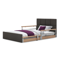 Opera Beds Solo Comfort Plus Profiling Floor Bed with adjustable height, wood rails, white bedding, purple blanket and pillow, side view.