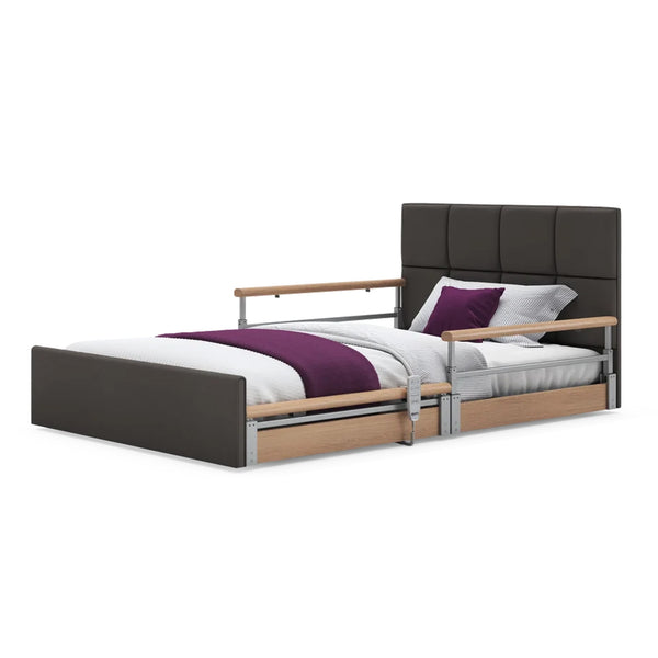Opera Beds Solo Comfort Plus Profiling Floor Bed with adjustable height, wood rails, white bedding, purple blanket and pillow, side view.