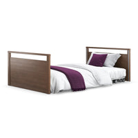 Opera Beds Solo SafeSide Profiling Floor Bed with white bedding, purple pillows and throw, front view.