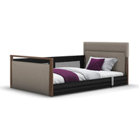 Opera Beds Solo SafeSide Upholstered Profiling Floor Bed with wood accents, headboard, safety rail and plush bedding, front view.
