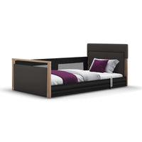 Opera Beds Solo SafeSide Upholstered Floor Bed with safety rails, grey bedding and purple pillow, modern look, front angle.