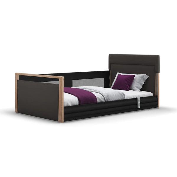 Opera Beds Solo SafeSide Upholstered Floor Bed with safety rails, grey bedding and purple pillow, modern look, front angle.