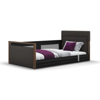 Opera Beds Solo SafeSide Leatherette bed with white bedding, purple throw, and two matching pillows, front view.