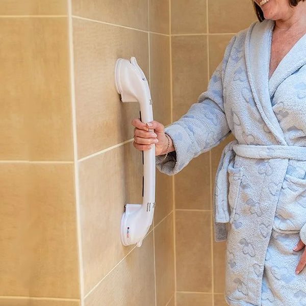 Woman holding Lifemax Stick ‘n’ Stay Grab Bar with locking suction cups on tiled bathroom wall, in use.