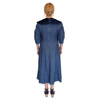 Woman in blue midi dress wearing Care Designs Tabard Style Adult Bib, blonde hair tied back, rear view.