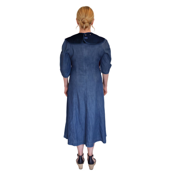 Woman with low bun wearing Care Designs Tabard Style Adult Bib against white background, front view.