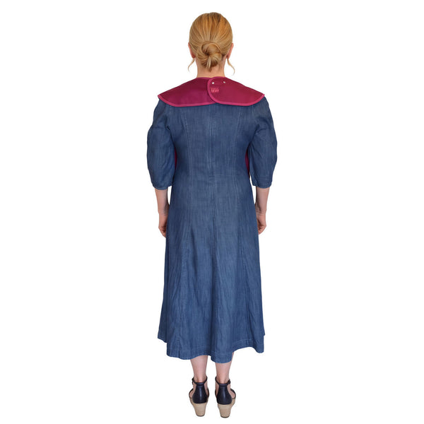 Woman wearing Care Designs Tabard Style Adult Bib standing with back to camera, white background, rear view.