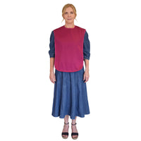 Woman wearing Care Designs Tabard Style Adult Bib over blue dress, white background, front view.