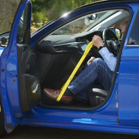 Person using Helping Hand Leg Up Leg Lifter to pull seatbelt across body in a blue car, product in use view.