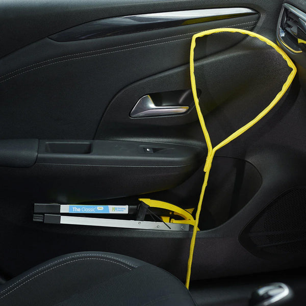 A Helping Hand Leg Up Leg Lifter secured in a car door pocket with a lock attached inside the door, side view.