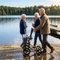 Topro Olympos All Terrain Rollator in use by a person walking outdoors with others, lakeside setting, trees and dock in background, in use view.