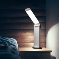 The Daylight Company Twist 2 Portable Lamp on a bedside table next to a bed, in use, room setting view.
