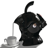 Uccello Kettle with ergonomic handle pouring hot water into a white cup on a saucer, in use.