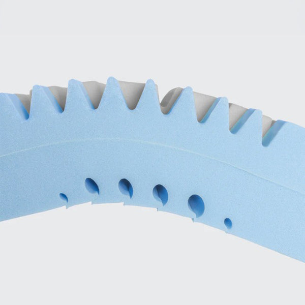 Memory foam layers with zigzag edges and ventilation holes on profiling mattress, close-up view.