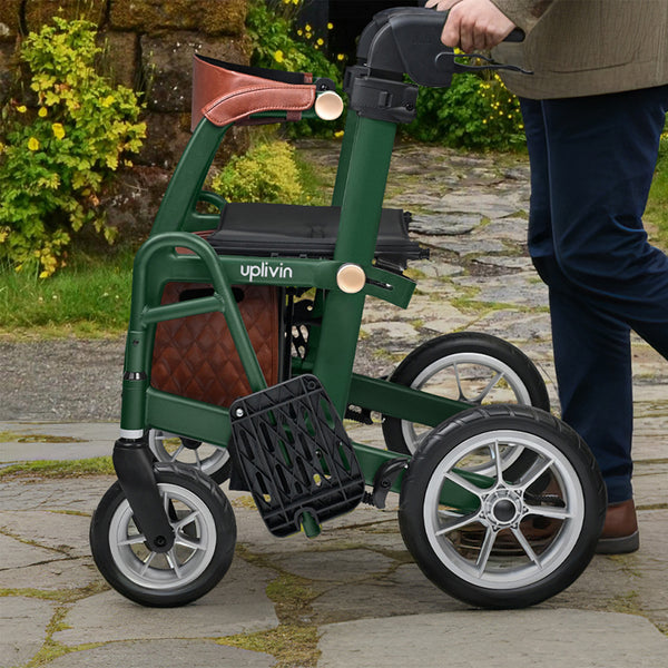Able2 Uplivin Glide 2-in-1 Rollator & Wheelchair with large wheels being pushed outdoors on a stone path, side view in use.