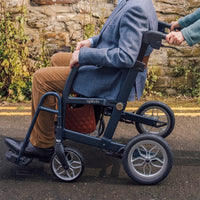 Person being pushed in an Uplivin Glide 2-in-1 Rollator and Wheelchair, side view.