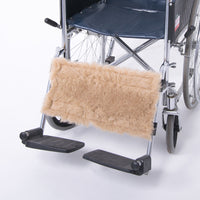 Wheelchair calf strap in pure wool for comfort, fitted above black footplates on metal frame, close-up view.