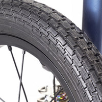 Urathon Yo-Yo Full Suspension Wheelchair wheel with a textured tread, similar to a bicycle tyre, blurred background, close-up.